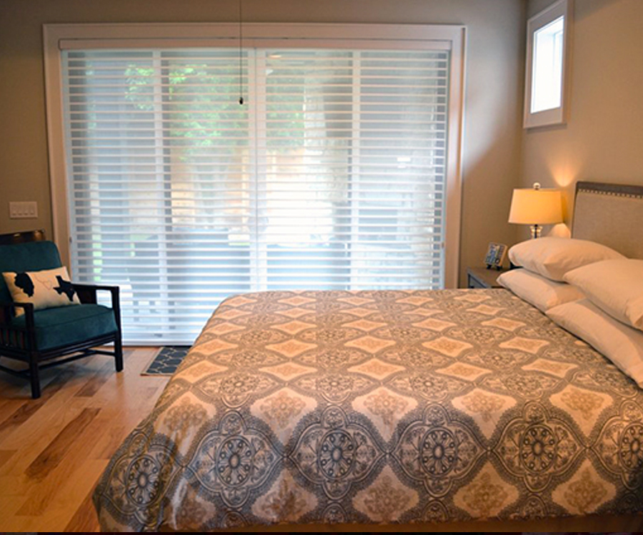 white sheer shades in master bedroom over large doors