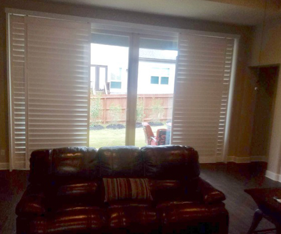 white plantation shutters slide to cover sliding glass doors in Austin TX