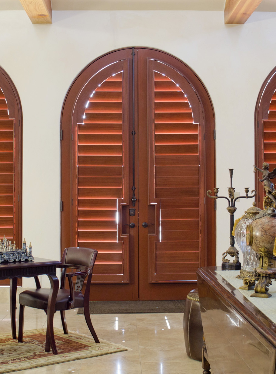 french doors arched opening covered with real wood shutters Austin