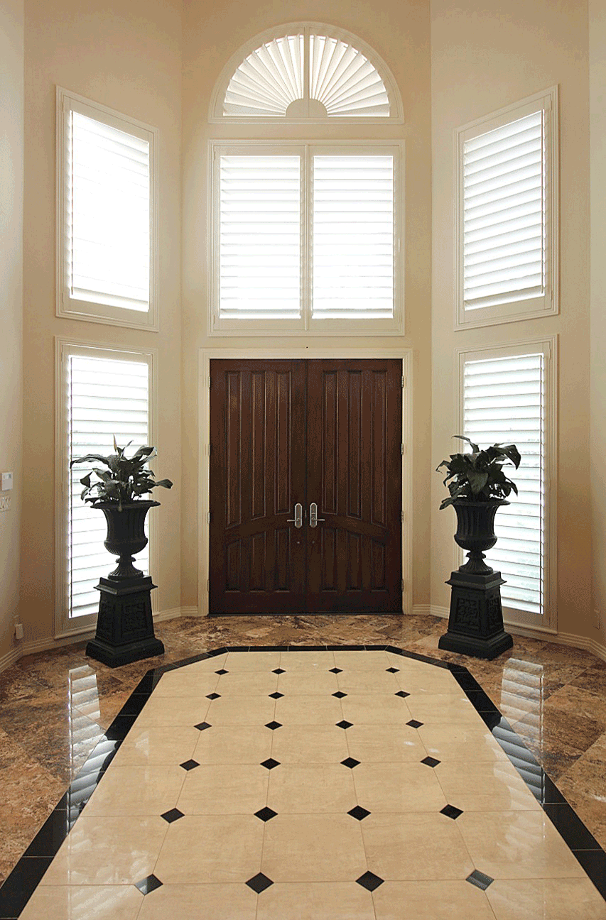 two story entryway with custom wood shutters on arched windows and standard windows in Austin TX home