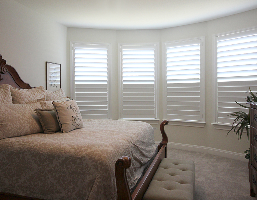 white plantation shutters half opened in master bedroom Austin