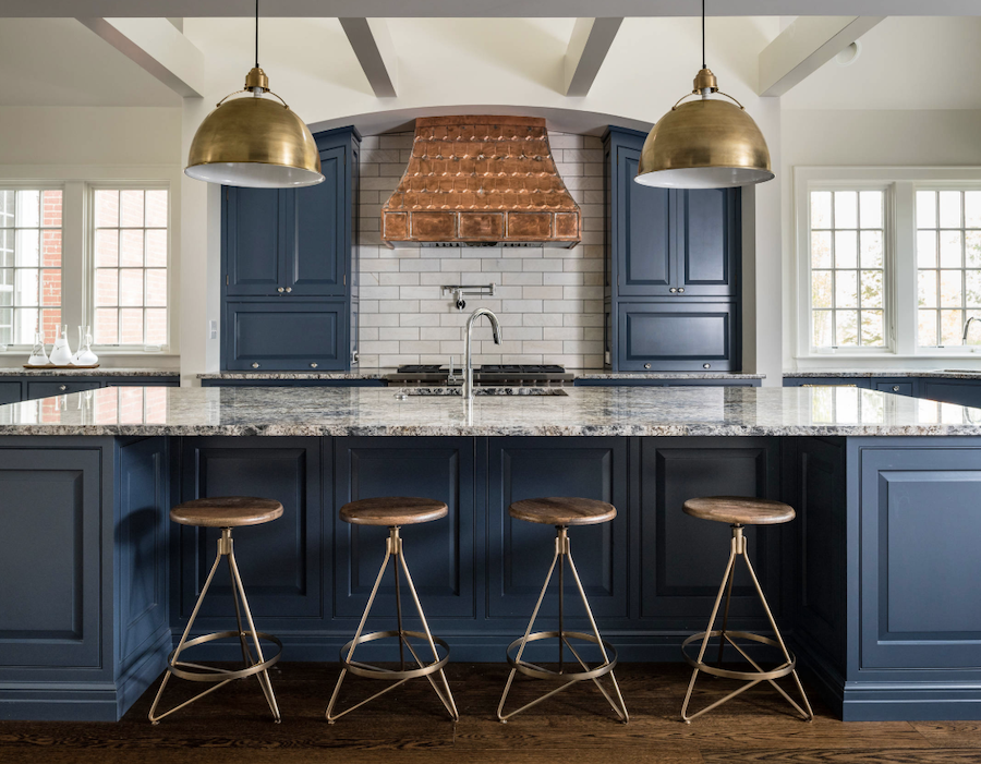 blue cabinetry in kitchen with antique brass pendants