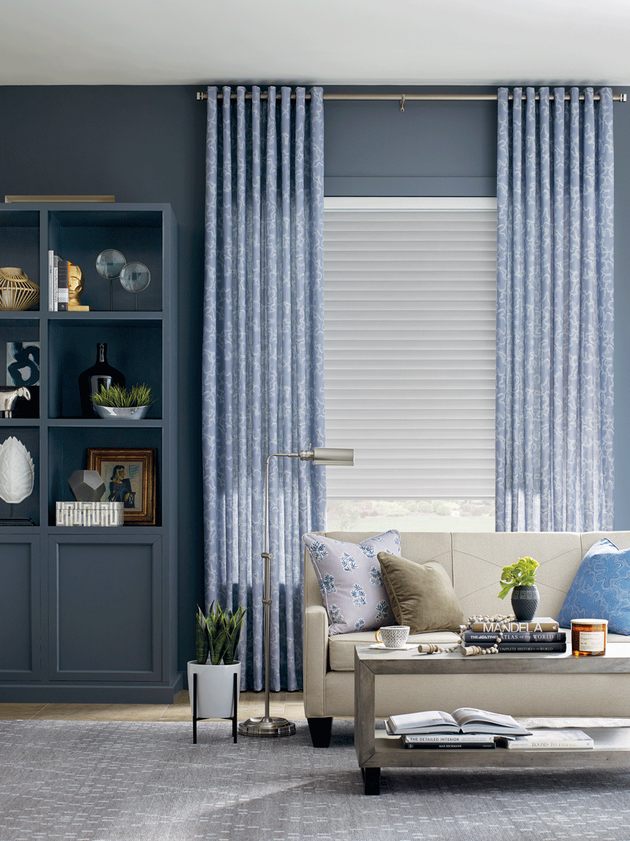 living room with blue drapery panels and white roller shades austin TX