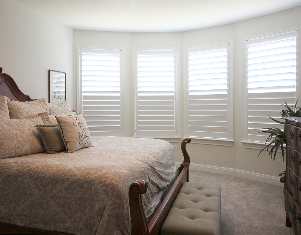 bay window area of bedroom with split tilt shutters on windows in Austin home