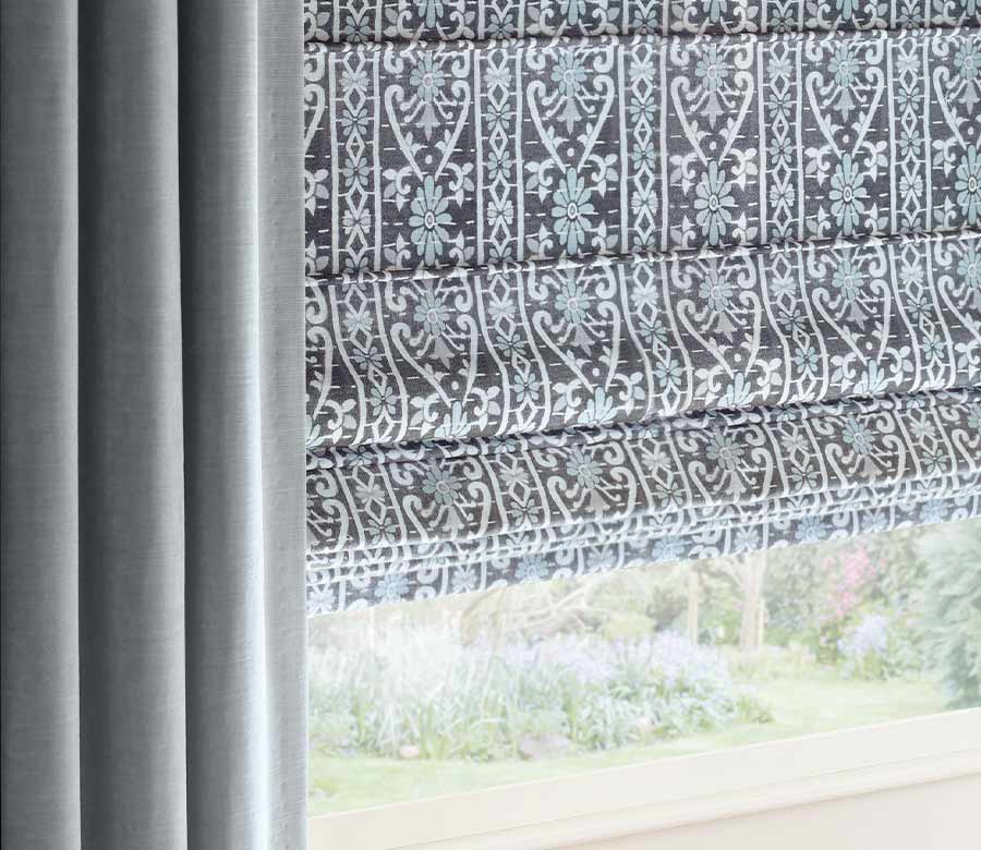 soft blue floor to ceiling custom drapery with uniquely patterned window shades Austin, TX