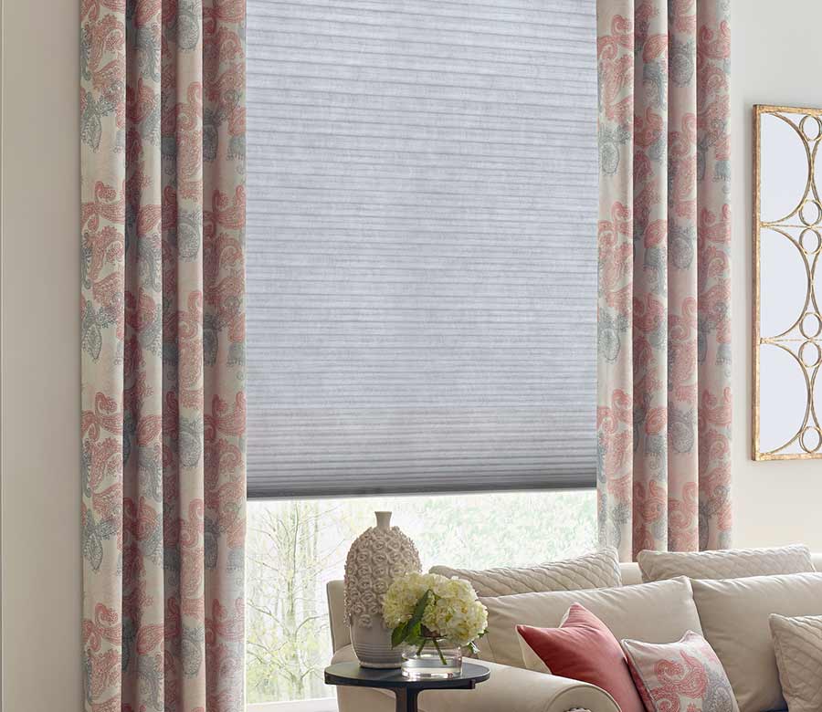 green and pink paisley patterned drapery with energy efficient honeycomb shades