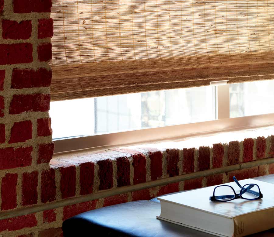 detail of custom woven shades in exposed brick apartment building austin, TX