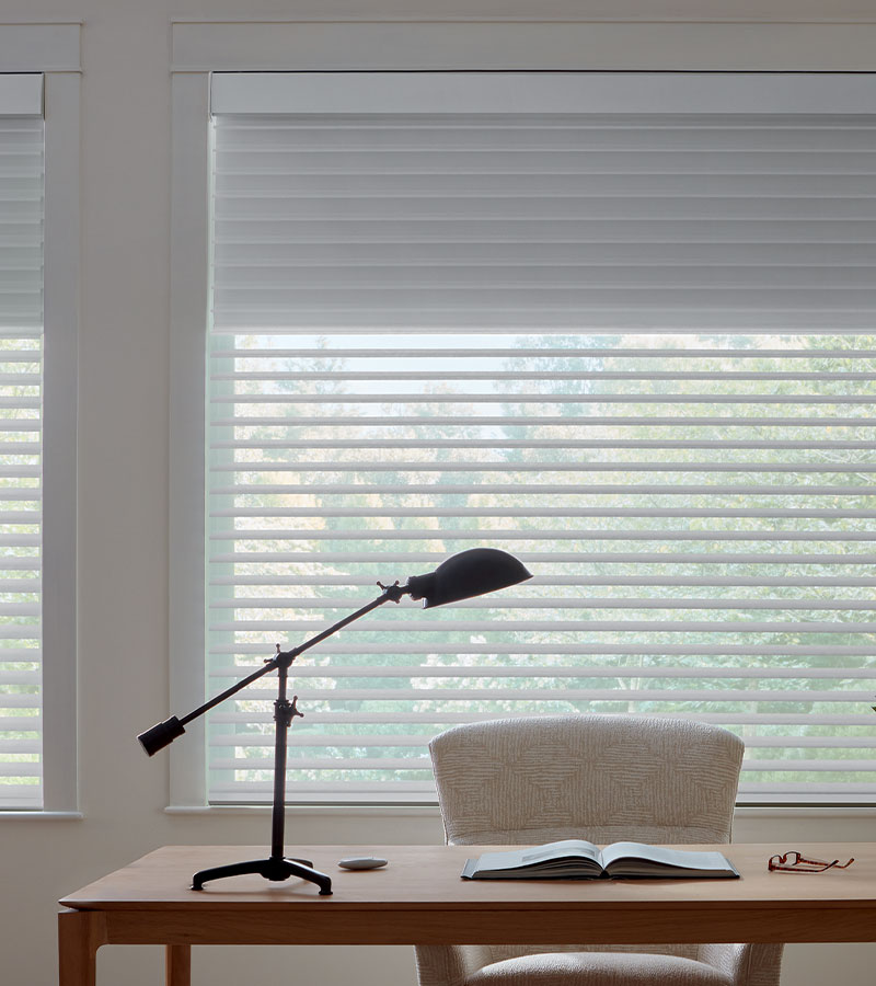 home office space with desk lamp and soft lighting through window treatments