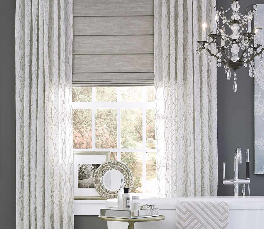 dramatic gray bathroom with custom window treatments, layered roman shades with side draperies for privacy and light control