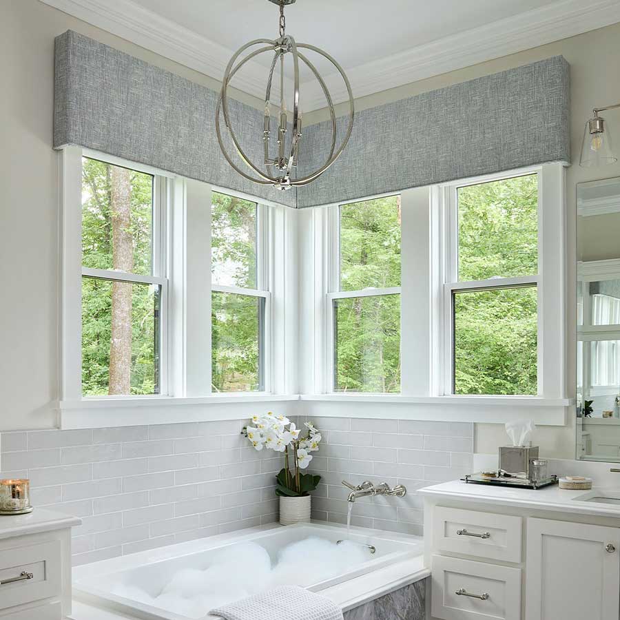 gray cornices in the bathroom against two sets of corner windows above a tub