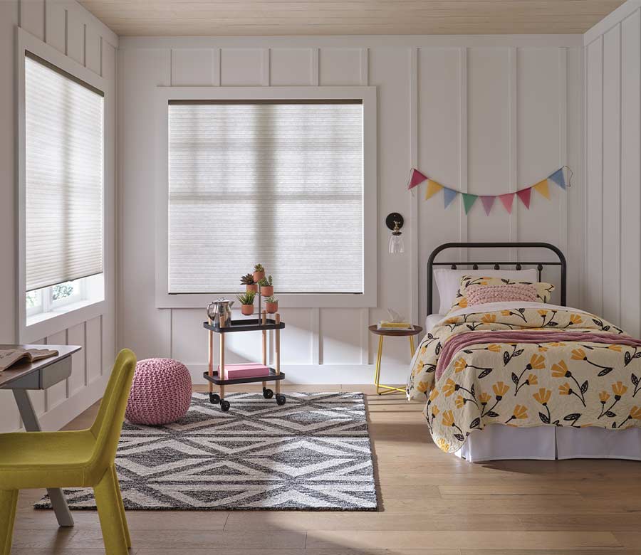children bedroom with white honeycomb cellular window shades and colorful bedding