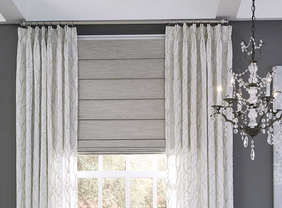 gray pinch pleat drapery with roman shades in living room