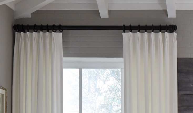 white pleated drapery with black rod
