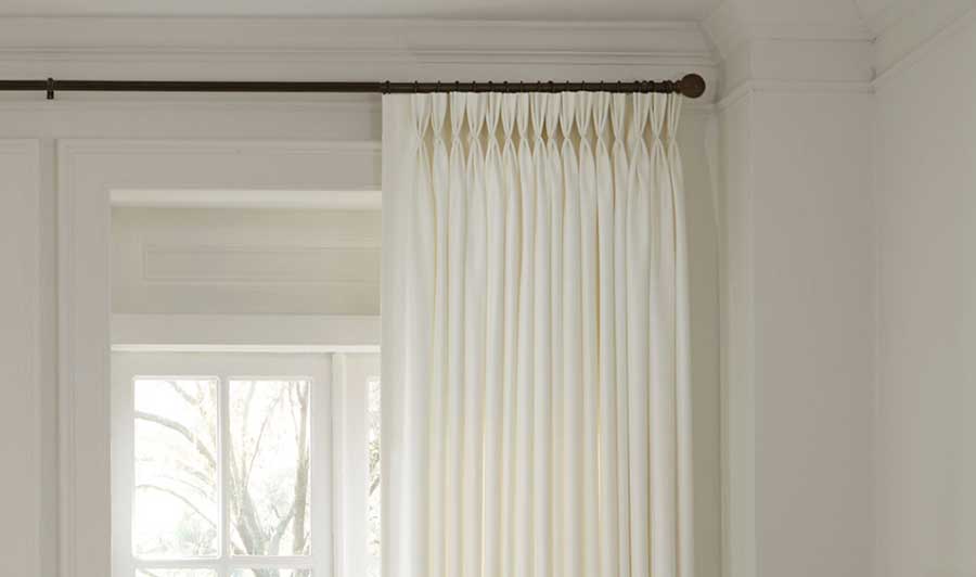 white triple pleat pinch drapery with black curtain rod